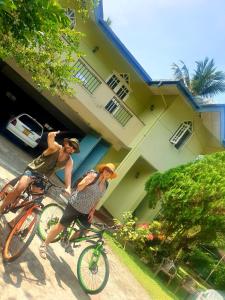 2 personnes sur un vélo devant une maison dans l'établissement Mohotti House, à Galle