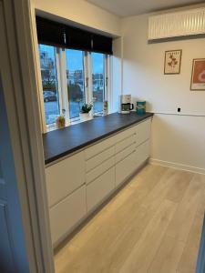 a kitchen with white cabinets and a window at Casa Home of Bricks - Downtown Holidays in Billund