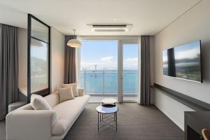 a living room with a couch and a view of the ocean at Urbanstay Busan songdo Beach in Busan