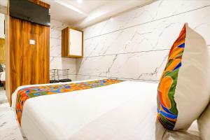 A bed or beds in a room at FabHotel Shubham Inn