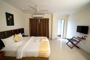 a bedroom with a bed and a television in it at Blossoms Hotel & Service Apartments in Chennai