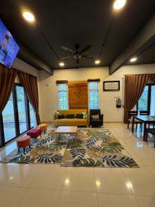Rumah Singgah Taman Belia Antarabangsa في آير كيروه: غرفة معيشة مع أريكة وسجادة