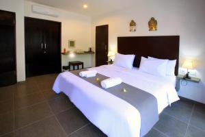 1 dormitorio grande con 1 cama grande con sábanas blancas en Gili Ocean Club - ADULTS ONLY, en Gili Trawangan