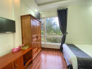 a bedroom with a bed and a large window at Cara Hostel & Spa in Da Lat
