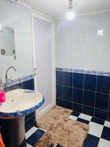 a bathroom with a sink and a blue and white tiles at Nabatean NIghts Home Stay in Wadi Musa