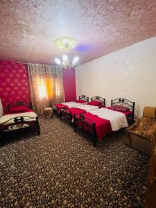 a room with four beds and a chandelier at Nabatean NIghts Home Stay in Wadi Musa
