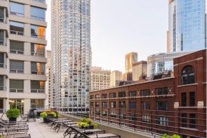 een groep tafels en banken in een stad met hoge gebouwen bij Courtyard by Marriott Chicago Downtown/River North in Chicago