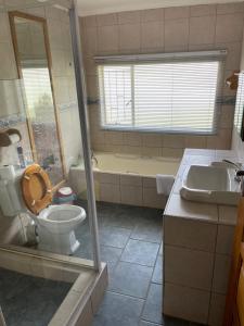 La salle de bains est pourvue de toilettes, d'une baignoire et d'un lavabo. dans l'établissement Eagles View Kungwini, à Bronkhorstspruit