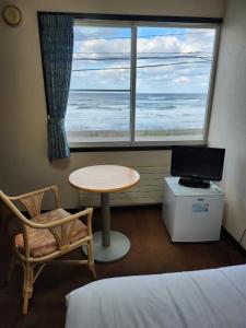 um quarto com uma cama, uma mesa e uma janela em ニャー助のホテルん em Shakotan