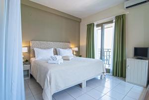 a bedroom with a bed with a towel on it at Kenta Beach Hotel in Agios Ioannis Pelio