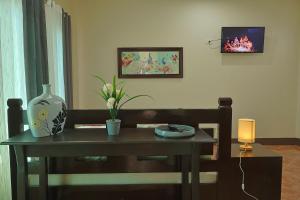 a room with a table with a vase on it at Point Vista Transient Accomodation in Daet