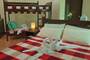 two towel swans are laying on a bed at Point Vista Transient Accomodation in Daet