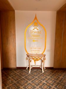 a table in a room with a sign on the wall at Hotel MEHAI HOUSE in Jaipur