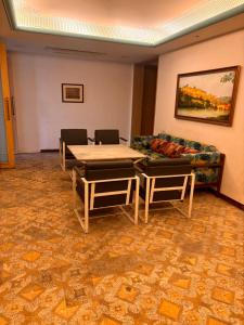 Hotel MEHAI HOUSE في جايبور: غرفة معيشة مع أريكة وطاولة وكراسي
