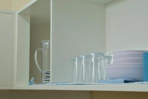 a cabinet filled with glasses and plates on a shelf at Point Vista Transient Accomodation in Daet +161 photos