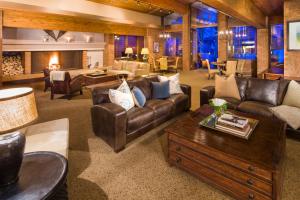 a living room with leather couches and a table at Mountain Chalet Snowmass in Snowmass Village