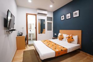 1 dormitorio con 1 cama grande y pared azul en Hotel Lyf Corporate Suites Meera Bagh en Nueva Delhi
