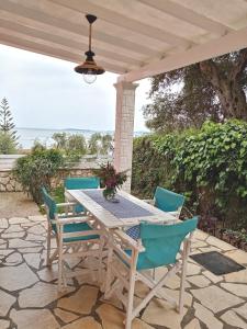 einen Tisch und Stühle auf einer Terrasse mit Meerblick im Hintergrund in der Unterkunft Kiki's Apartments in Barbati