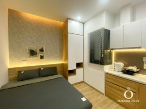 a small bedroom with a bed and a kitchen at PANDORA HOUSE in Ho Chi Minh City