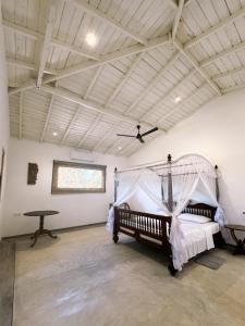 a bedroom with a bed with a mosquito net at Ancient Talpe in Galle