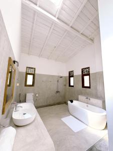 a white bathroom with a tub and a sink and a tub at Ancient Talpe in Galle +57 photos
