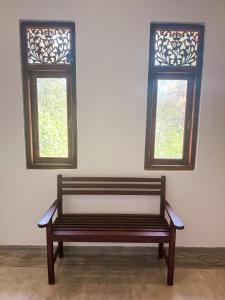 a bench sitting in a room with two windows at Ancient Talpe in Galle