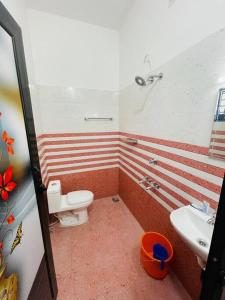 a bathroom with a toilet and a sink at Vacation Guest House in Trivandrum