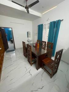 a dining room with a wooden table and chairs at Vacation Guest House in Trivandrum