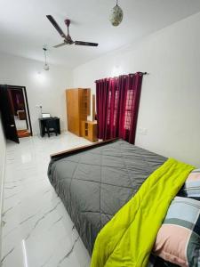 a bedroom with a bed and a ceiling fan at Vacation Guest House in Trivandrum