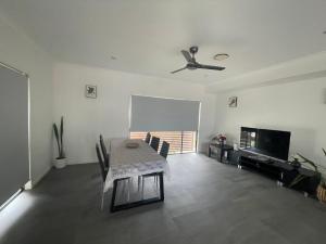 sala de estar con mesa y ventilador de techo en Best Brisbane location to enjoy vocation, en Brisbane