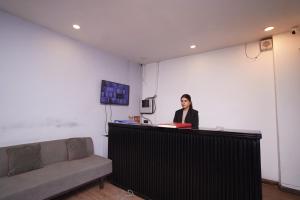 Una mujer parada en un mostrador en una habitación en Hotel Lyf Corporate Suites Meera Bagh en Nueva Delhi