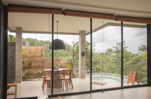 a dining room with sliding glass doors leading to a pool at THE HILL By The Villas 100 in Bogor