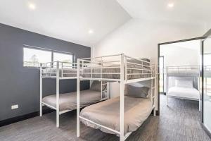 two bunk beds in a room with a mirror at NEW! Charming & Spacious 4BR Retreat in Pitt Town 