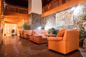 a living room with orange couches and a table at Hotel Molika in Magarevo