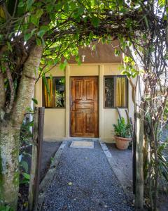 a front door of a house with trees at Casa kattleya in Tortuguero