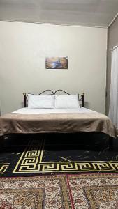 1 dormitorio con 1 cama con una pintura en la pared en Homestay MYZARAH en Pasir Puteh