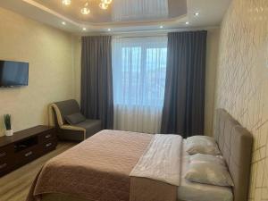 ein Schlafzimmer mit einem Bett, einem Stuhl und einem Fenster in der Unterkunft Apartment - Dzhordzha Vashynhtona in Lwiw