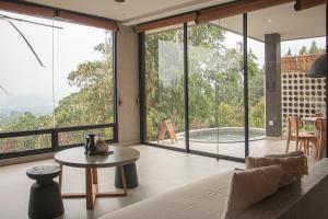 a living room with large windows and a table at THE HILL By The Villas 100 in Bogor