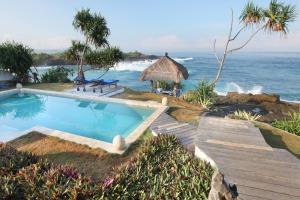 a swimming pool next to the ocean with a beach at Villa Lumba Lumba - Oceanfront & Spectacular View! in Nusa Lembongan