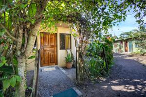 a house with a wooden door and some trees at Casa kattleya in Tortuguero