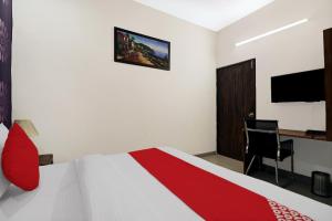 a bedroom with a bed and a desk and a television at Flagship Hotel Sangeet in Faridabad