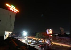 una gasolinera por la noche con coches aparcados en un aparcamiento en Shrinidhi Residency Pune, en Pune
