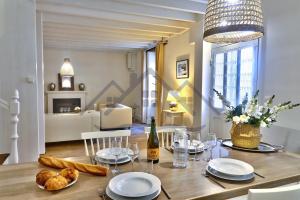 - une salle à manger avec une table, du pain et une bouteille de vin dans l'établissement LocaLise - M4 - La maison de la pointe de Lechiagat - Accès à deux pas d'une terrasse vue mer privative - Wifi inclus - Draps inclus - Animaux bienvenus, à Tréffiagat