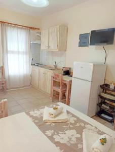 a kitchen with a white refrigerator and a table at Peaceful Bay in Megas Yialos-Nites