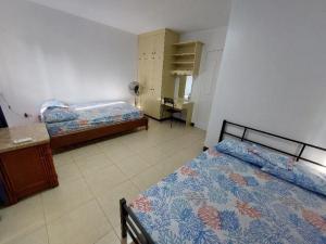 a bedroom with two beds and a desk in it at Vacation Town House Near Mactan Cebu Airport in Mactan