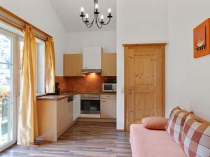 a kitchen with a couch and a door to a room at Spacious Apartment in GroBarl with Sauna in Grossarl