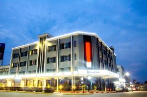 a large white building with a red stripe on it at Imperial Hotel Express in Kisumu