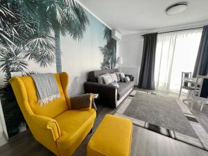 奥托佩尼Mathias Airport Residences & Therme-Self Check-in的客厅里有一把黄色的椅子和一张沙发