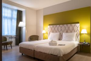 Postel nebo postele na pokoji v ubytování Hotel Au Quartier