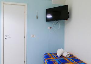 a room with a bed with a tv on the wall at C sta o mar for in Naples